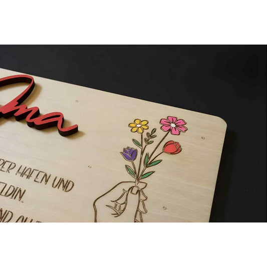 Holz-geschenkkarte oma aus hellem holz mit lasergravur hand hält bunte blumen und rotem 3d schriftzug mama