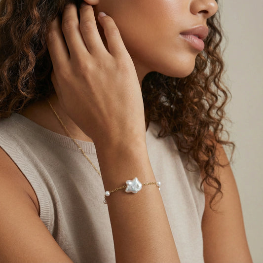 Perlenarmband mit Süßwasserperlen von flyliving, mit großem Barockperlenanhänger und goldfarbener Kette am Handgelenk.