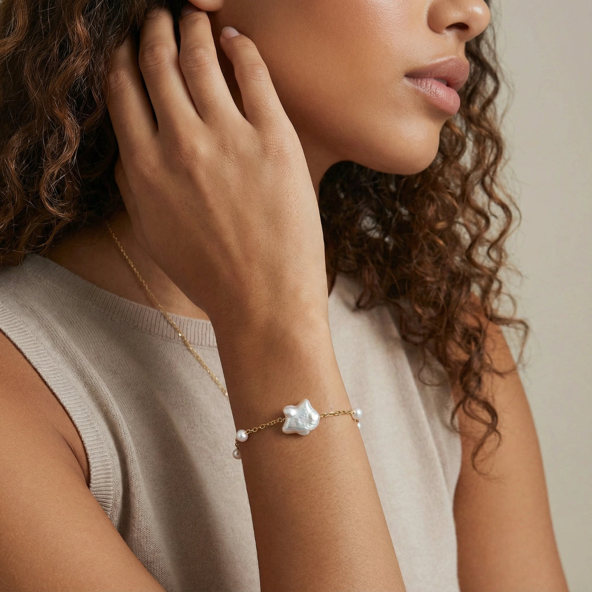 Perlenarmband mit Süßwasserperlen von flyliving, mit großem Barockperlenanhänger und goldfarbener Kette am Handgelenk.