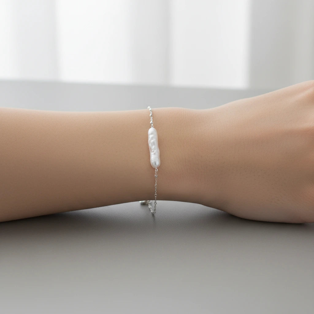 Barockes Perlenarmband von flyliving, auf einem Arm mit silberner Kette.