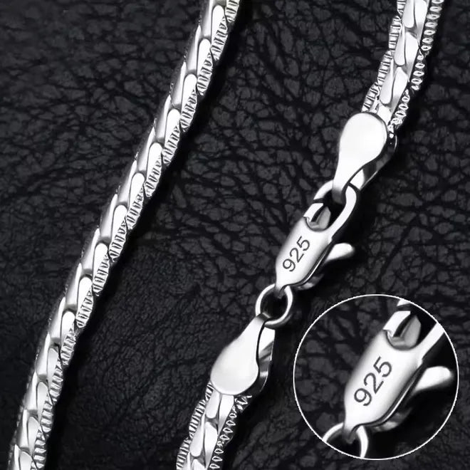 Eine Nahaufnahme der flyliving Halskette „Horst-Peter“, einer silbernen Gliederkette mit einem 925er Sterlingsilber-Karabinerverschluss, dargestellt auf strukturiertem Schwarz. Ein Einschub hebt die 925er-Markierung auf dem Verschluss hervor.