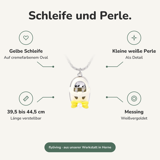 Erklärbild Schleife und Perle. Gelbe Schleife: Auf cremefarbenem Oval, Kleine weiße Perle: Als Detail, 39,5 bis 44,5 cm: Länge verstellbar, Messing: Weißvergoldet