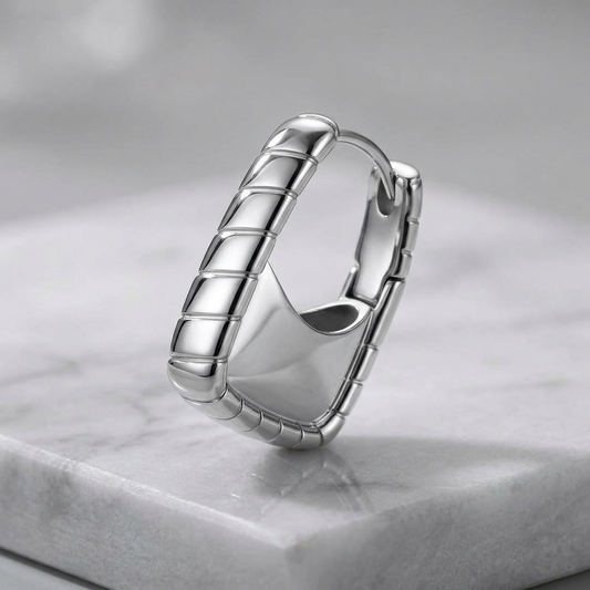 Platinum-plated 925 sterling silver textured hoop earring by flyliving, featuring a ribbed design and smooth inner surface on marble.