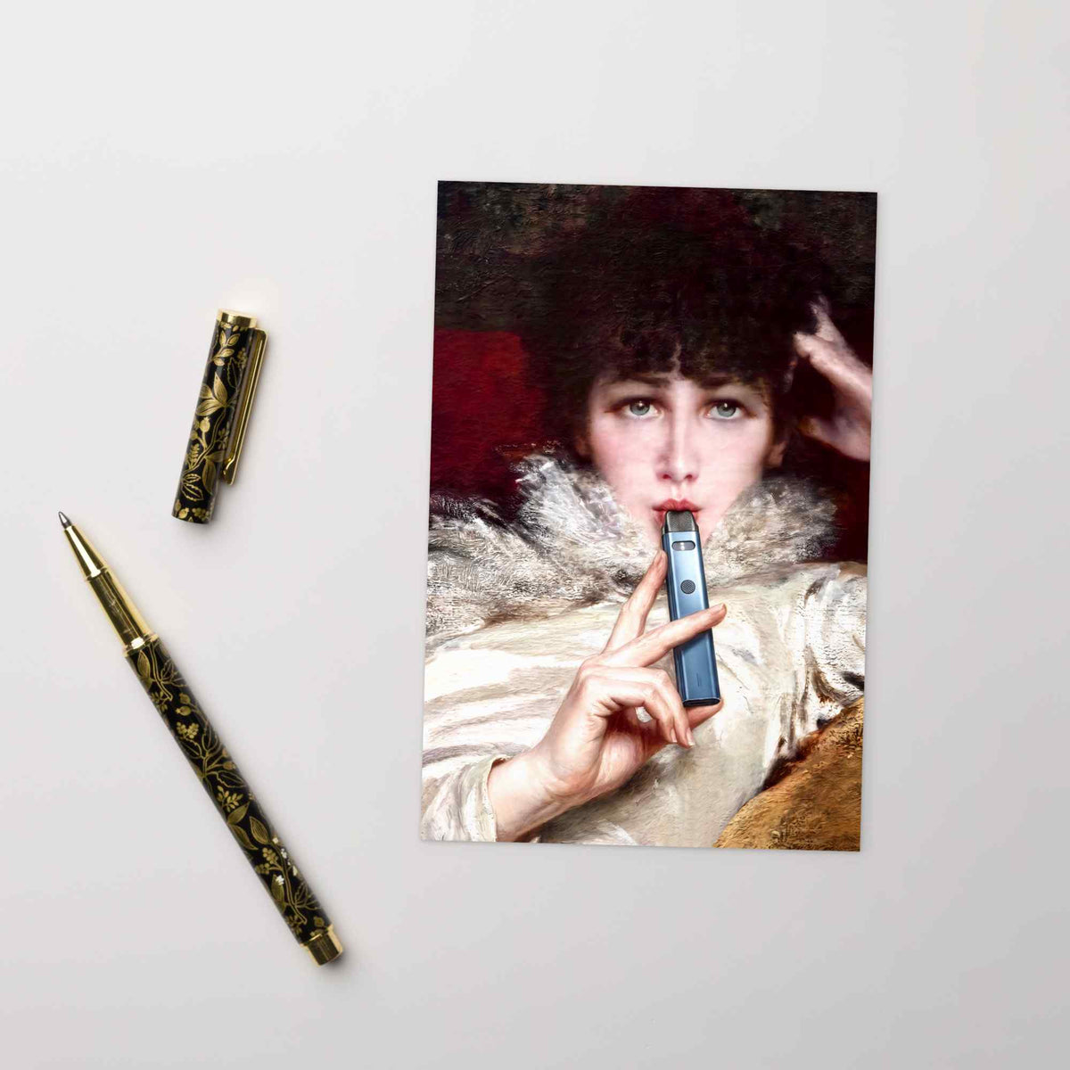 Vintage-Postkarte mit rauchender Dame und E-Zigarette auf weißem Untergrund neben einem goldenen Füllfederhalter