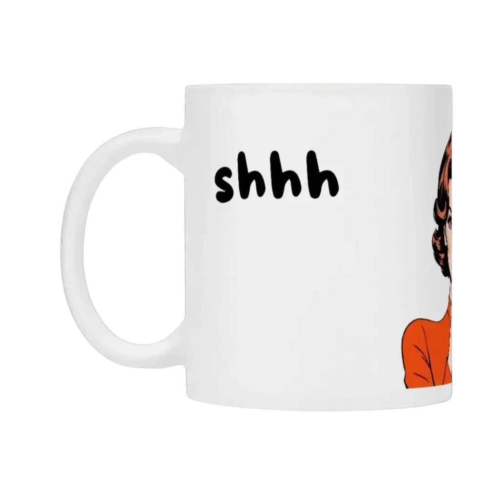 Weiße Tasse mit "shhh" Aufdruck von flyliving, mit einer Comicfigur verziert, Seitenansicht.
