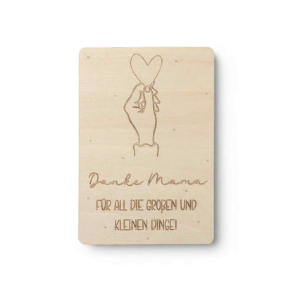 Eine hellholz holzkarte danke mama mit eingravierter hand, die ein herz hält und dem text danke mama für all die großen und kleinen dinge