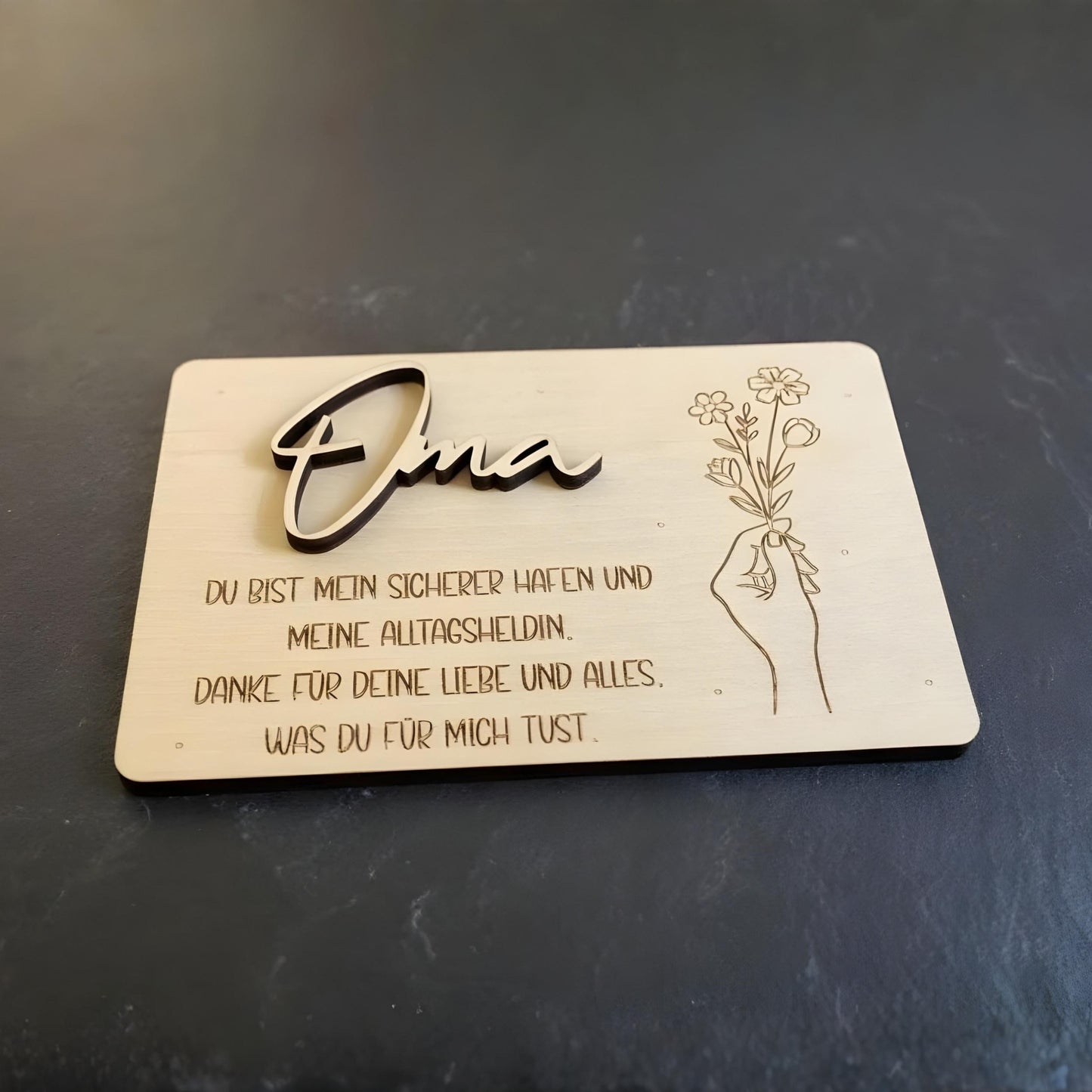 A handgefertigte hellholz geschenkkarte oma mit gravur in kursiver schrift und blumenskizze