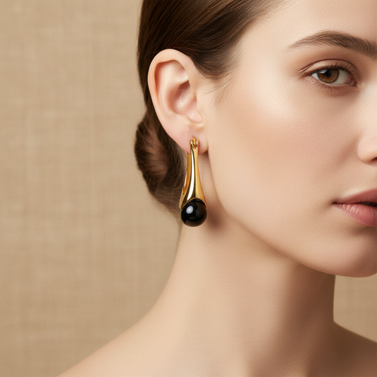 18K gold-plated sterling silver drop earrings with black agate bead by flyliving, featuring a sleek teardrop shape worn on a model's ear.