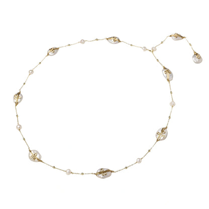 Long gold chain necklace with baroque pearls wrapped in leaf designs and small freshwater pearls spaced along the strand