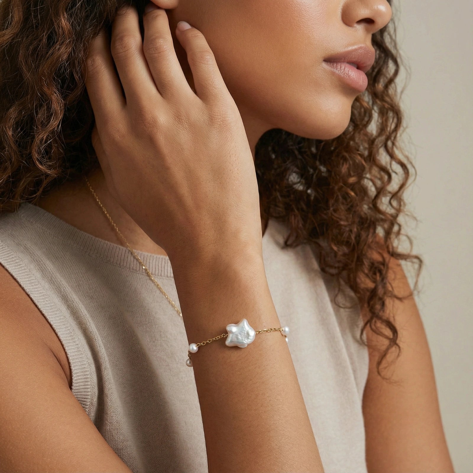 Perlenarmband mit Süßwasserperlen von flyliving, mit großem Barockperlenanhänger und goldfarbener Kette am Handgelenk.