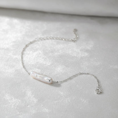 Barockes Perlenarmband von flyliving, mit silberner Kette und Karabinerverschluss auf weißem, samtigem Hintergrund.
