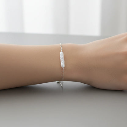 Barockes Perlenarmband von flyliving, auf einem Arm mit silberner Kette.