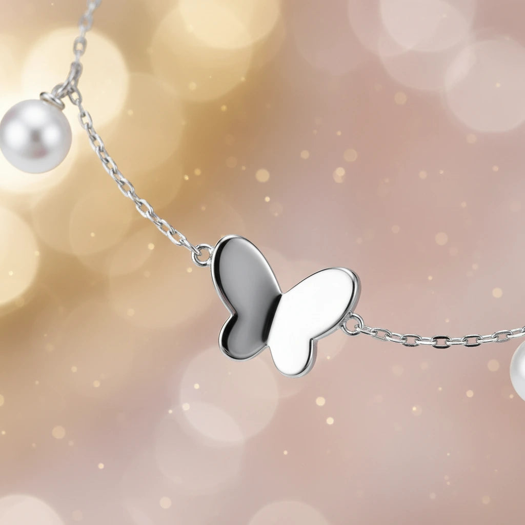 Silbernes Armband mit Schmetterlingsanhänger von flyliving, verziert mit einer einzelnen Perle.