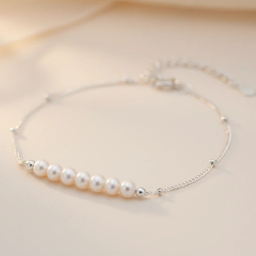 Zartes Perlenarmband von flyliving mit silberfarbener Kette und kleinen Kügelchen.