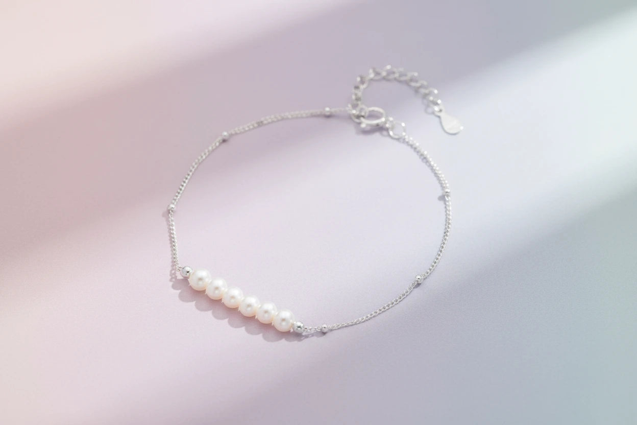 Perlenarmband von flyliving, mit silberner Kette und einem Band aus sechs weißen Perlen.