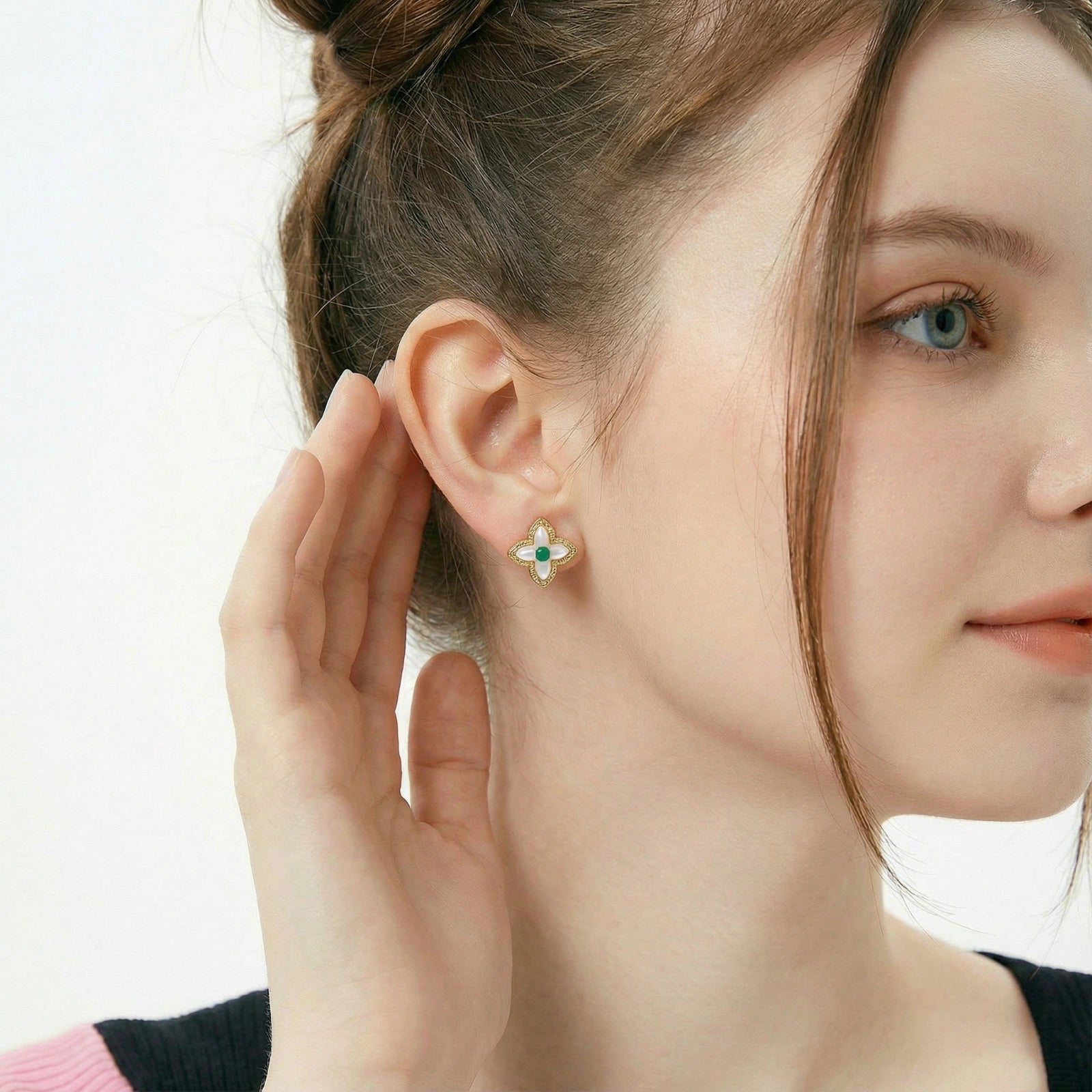 Vergoldete Glücks-Kleeblatt-Ohrringe von flyliving, mit grünen Akzenten und filigranem, floralem Design am Ohr einer Frau.