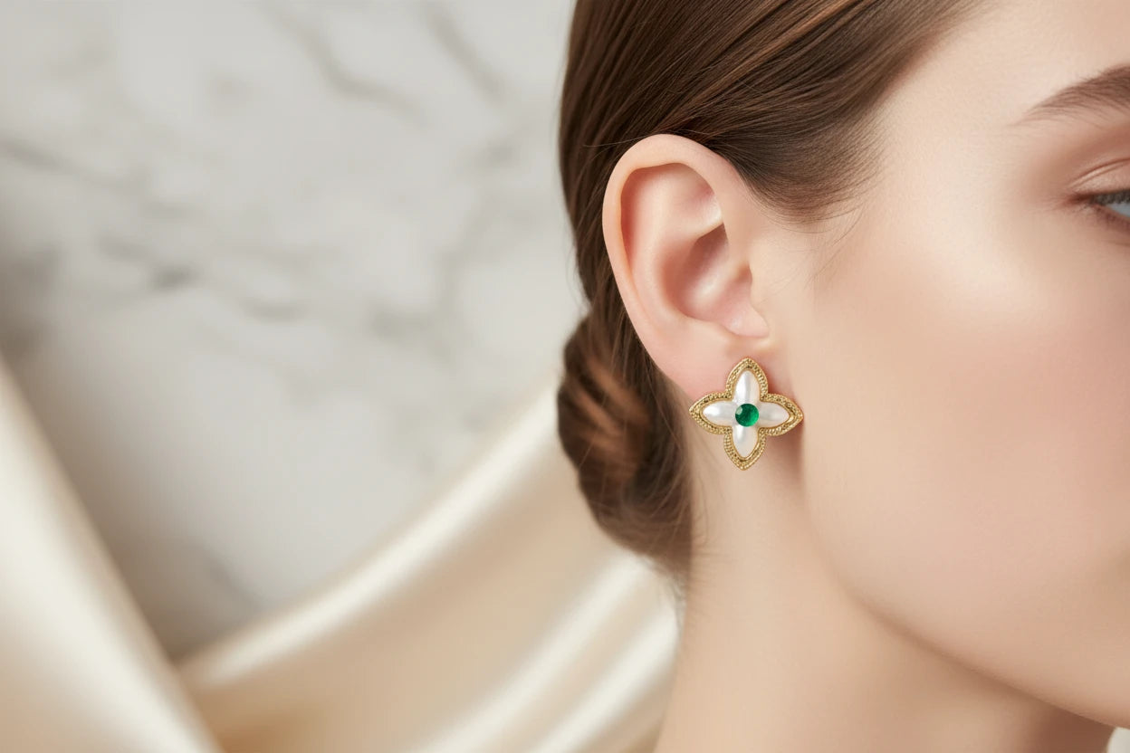 Vergoldete Glücks-Kleeblatt-Ohrringe von flyliving, mit grünen Akzenten, an einem Ohr getragen.