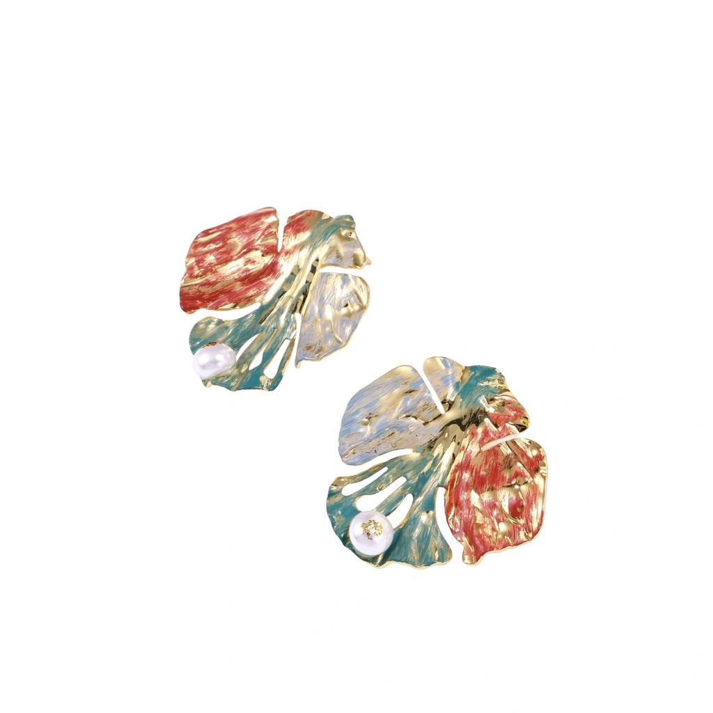 Artistic monstera-shaped earrings with teal, coral, and cream enamel brushstrokes, gold trim, and white pearl accent