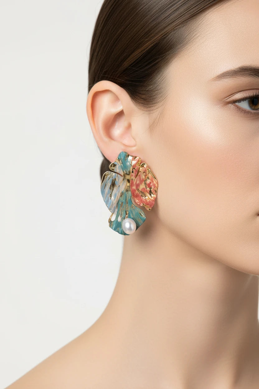 Vergoldete Monstera Muse Ohrringe von flyliving, mit blauen und rosafarbenen Akzenten und einer einzelnen Perle.