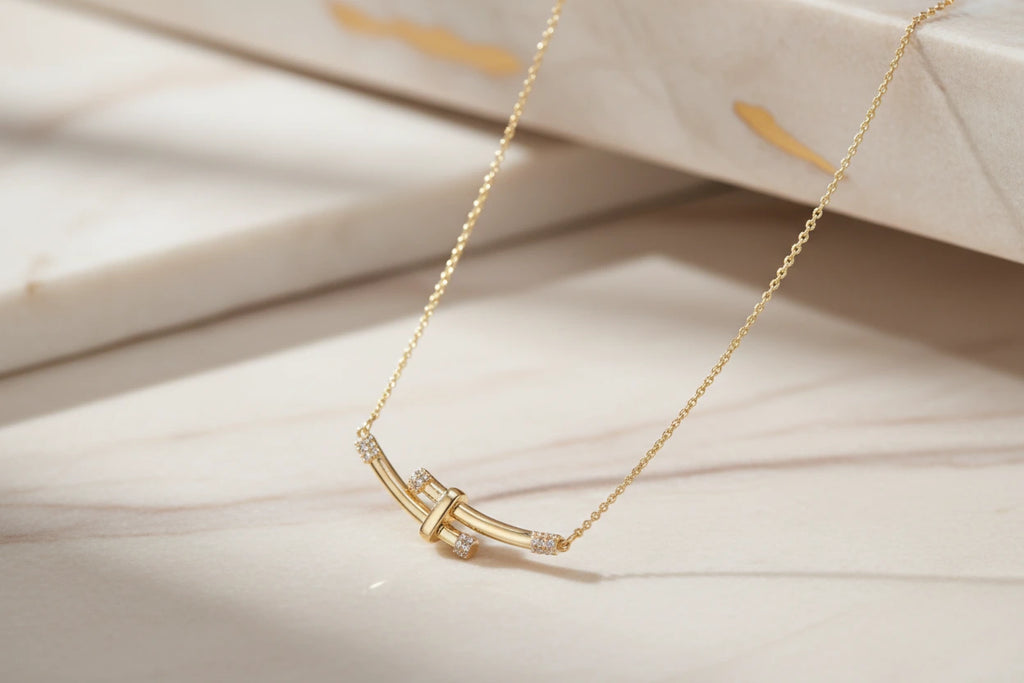 Goldene Bamboo Crystal Arc Halskette von flyliving, mit Kristallakzenten auf marmorähnlichem Hintergrund.