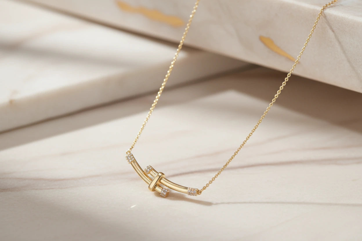 Goldene Bamboo Crystal Arc Halskette von flyliving, mit Kristallakzenten auf marmorähnlichem Hintergrund.