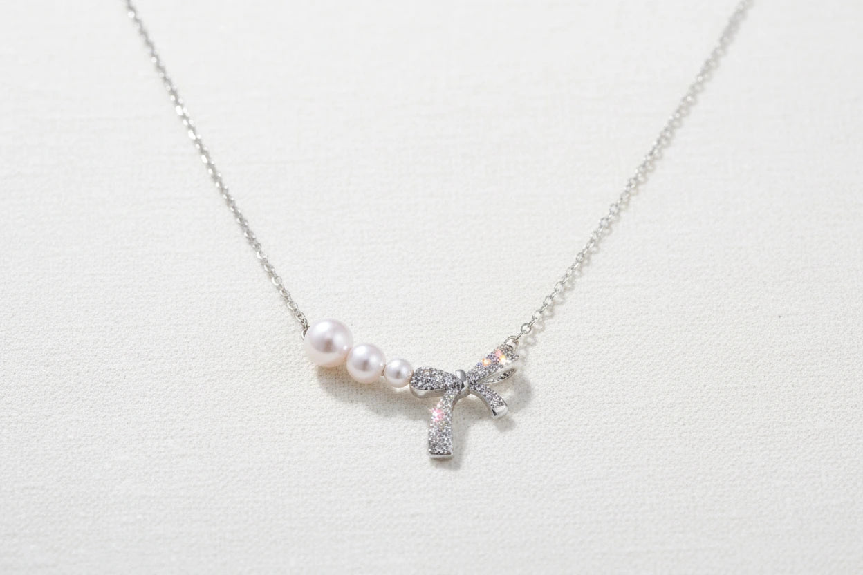 Perlenbogen-Halskette, versilbert von flyliving, mit drei Perlen und Schleifendetail.