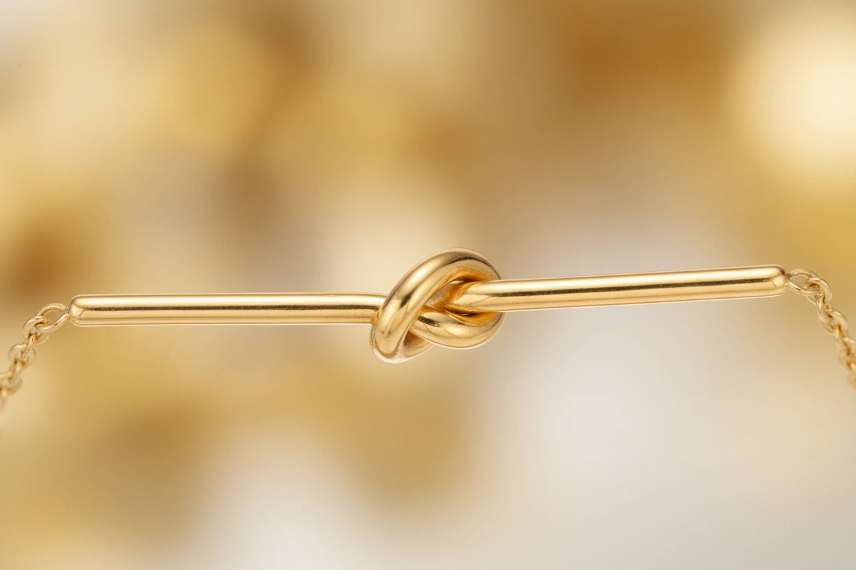 Goldfarbenes Twisted Knot Bar Armband von flyliving, Detailaufnahme mit Knotenmotiv und zarter Kette.