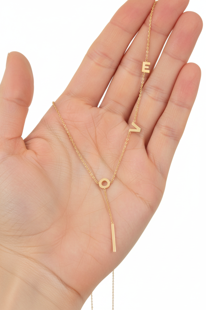 18K gold-plated LOVE Y-chain necklace by flyliving held in a palm.