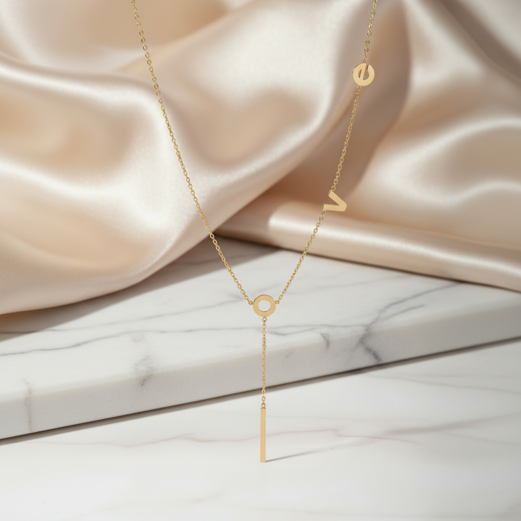18K gold-plated LOVE Y-necklace by flyliving, with an O charm and vertical bar pendant, on marble.