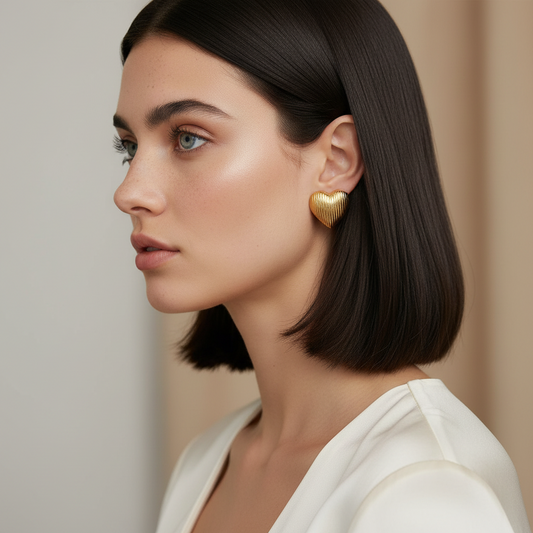 18K gold-plated textured heart stud earrings by flyliving, with a ribbed finish, seen in a woman's side profile.