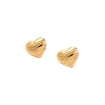 Goldfarbene Herz-Ohrstecker mit Rillen im schrägen Winkel, freigestellt auf weißem Hintergrund