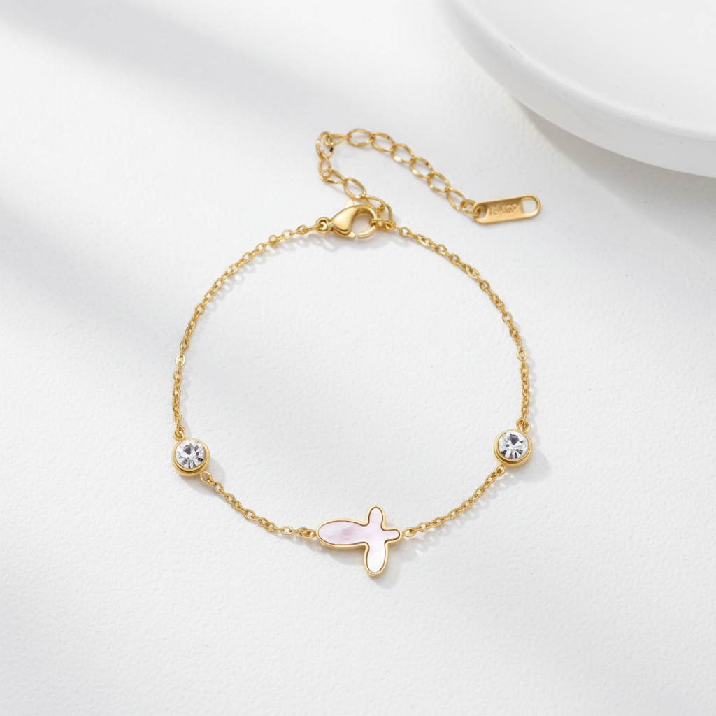 18K gold-plated bracelet by flyliving with a mother-of-pearl cross charm and two round crystals.