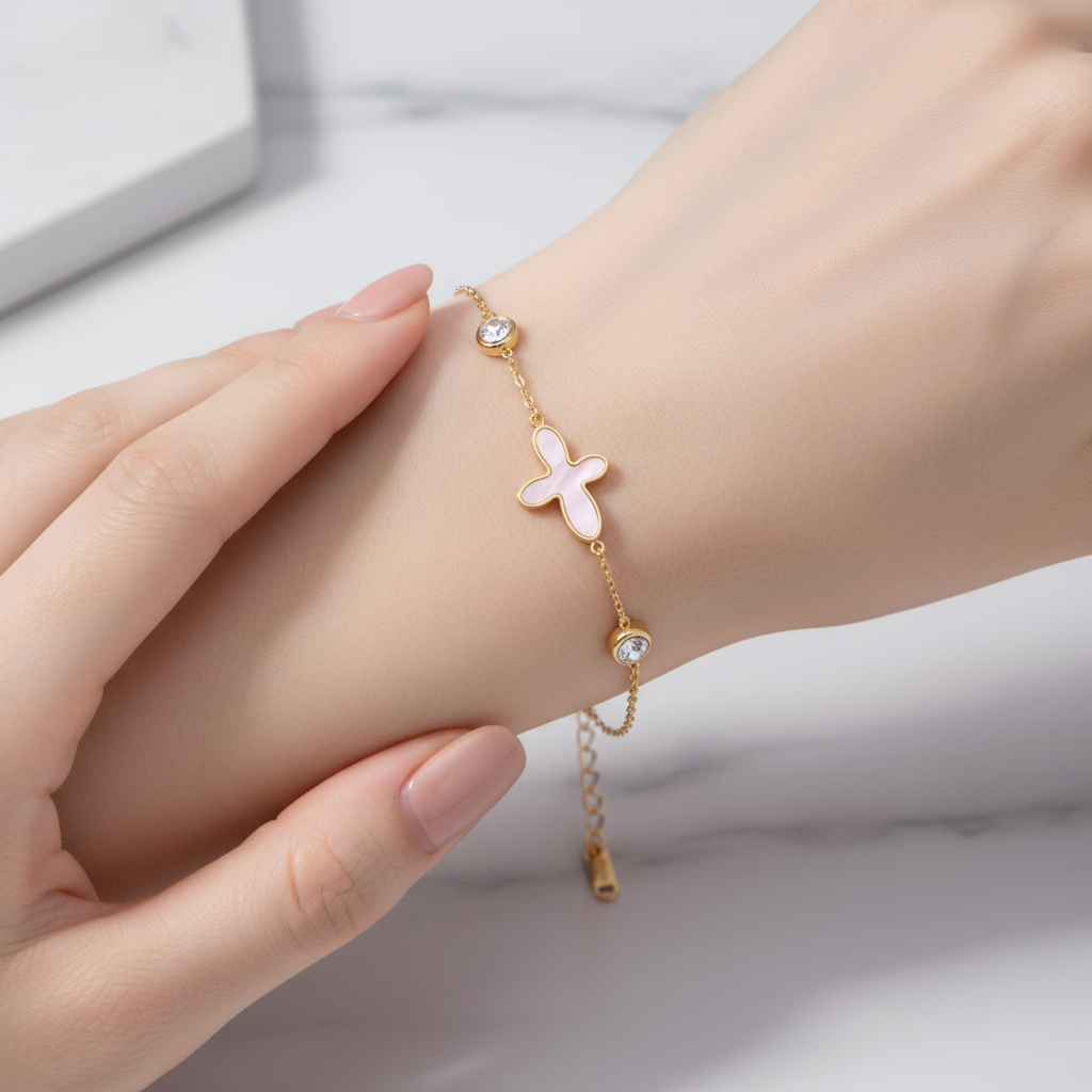 18K gold-plated butterfly bracelet with pink mother-of-pearl and crystals by flyliving, worn on a wrist.