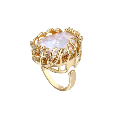 Goldener Ring mit offener Schiene, Barockperle und Blütenkrone mit Steinchen, freigestellt in Schrägansicht
