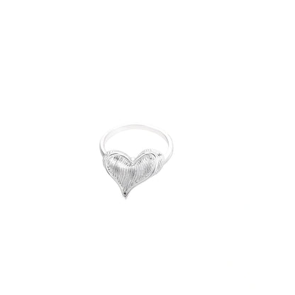 Silver ring with 3D heart formed by textured feather-like elements, white gold plated eco-brass on neutral background.