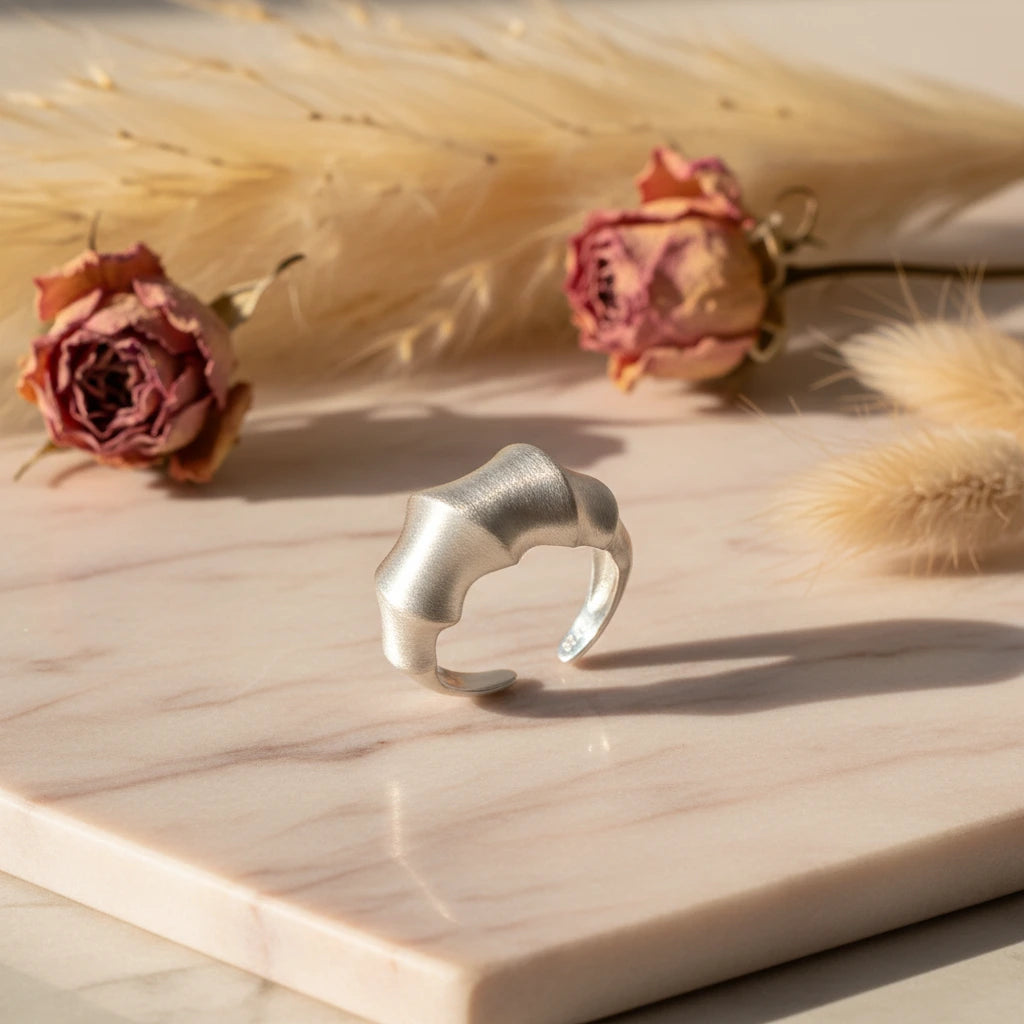 Statement Ring aus Silber von flyliving, mit organisch geformtem Bambus-Design auf Marmorplatte.