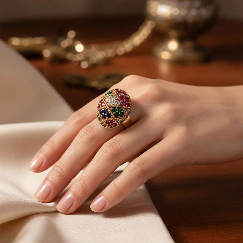 Vergoldeter Mosaik-Ring "Empress" von flyliving, mit farbigen Schmucksteinen im Schachbrettmuster auf einer Hand präsentiert.
