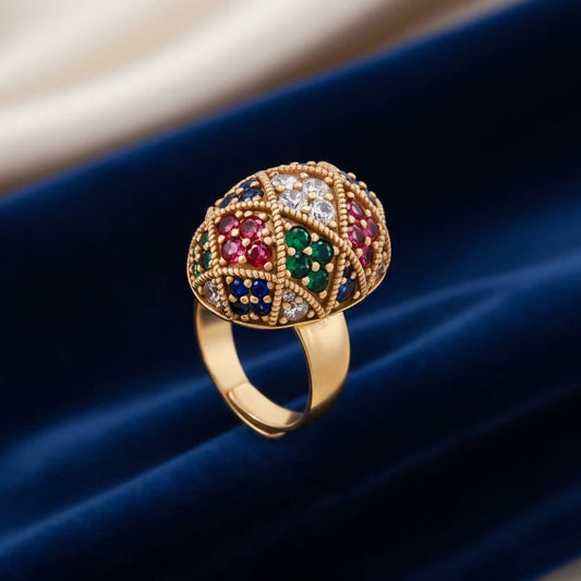 Vergoldeter Ring Empress Mosaic von flyliving mit bunten Edelsteinen besetzt auf blauem Samtstoff.