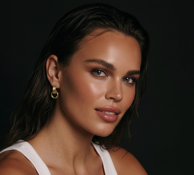 Gold-plated stainless steel geometric loop drop earrings by flyliving, worn by a model in a white tank top.