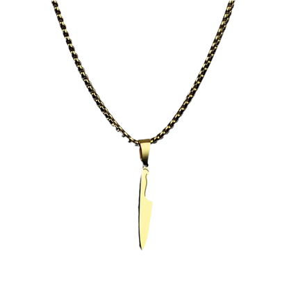 Die goldene Halskette „Laura“ von flyliving präsentiert einen Kochmesser-Anhänger als eleganten Edelstahl-Anhänger, der sich vor einem schlichten schwarzen Hintergrund abhebt.