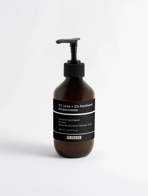 Braune Körpercreme mit Urea und Panthenol von Flycare, in einer Pumpflasche mit schwarzer Etikettierung.
