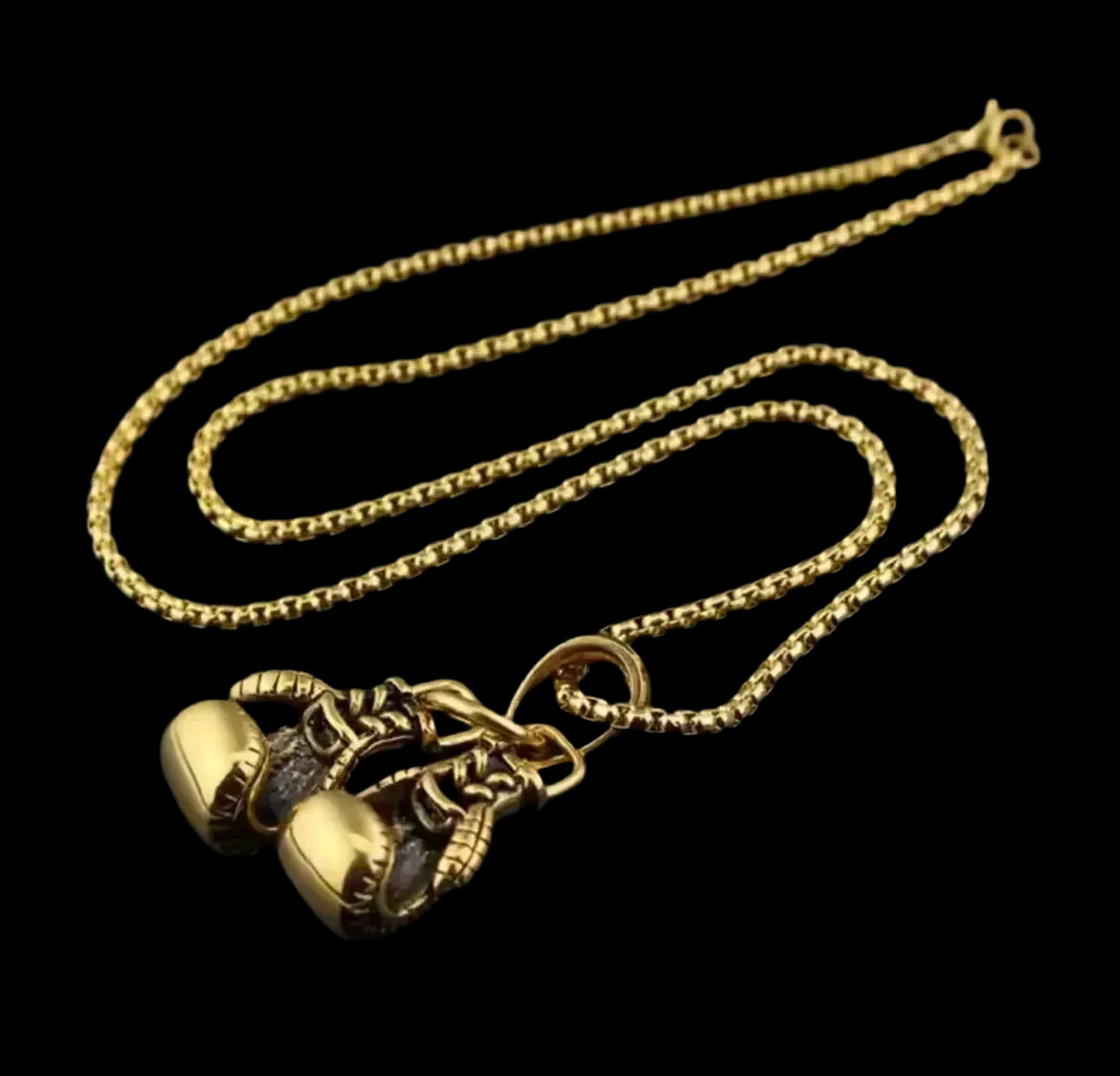 "Die flyliving Halskette „Angela“ zeigt zwei detailreiche, goldene Boxhandschuhe aus Edelstahl, unisex und elegant nebeneinander an einer Kette arrangiert."