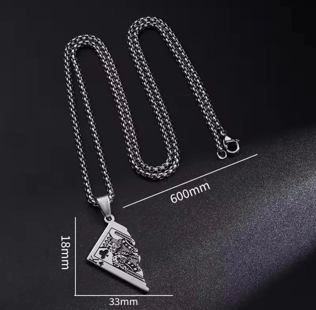 "Die Halskette „Erna“ von flyliving in Silber ist eine Halskette aus Edelstahl in Silber mit einer 600 mm langen Kette und einem dreieckigen (33 x 18 mm) Anhänger mit eingravierten Löwen- und Kartenmotiven, inspiriert von Halbspielkarten-Designs, auf Schwarz mit Maßangaben dargestellt."