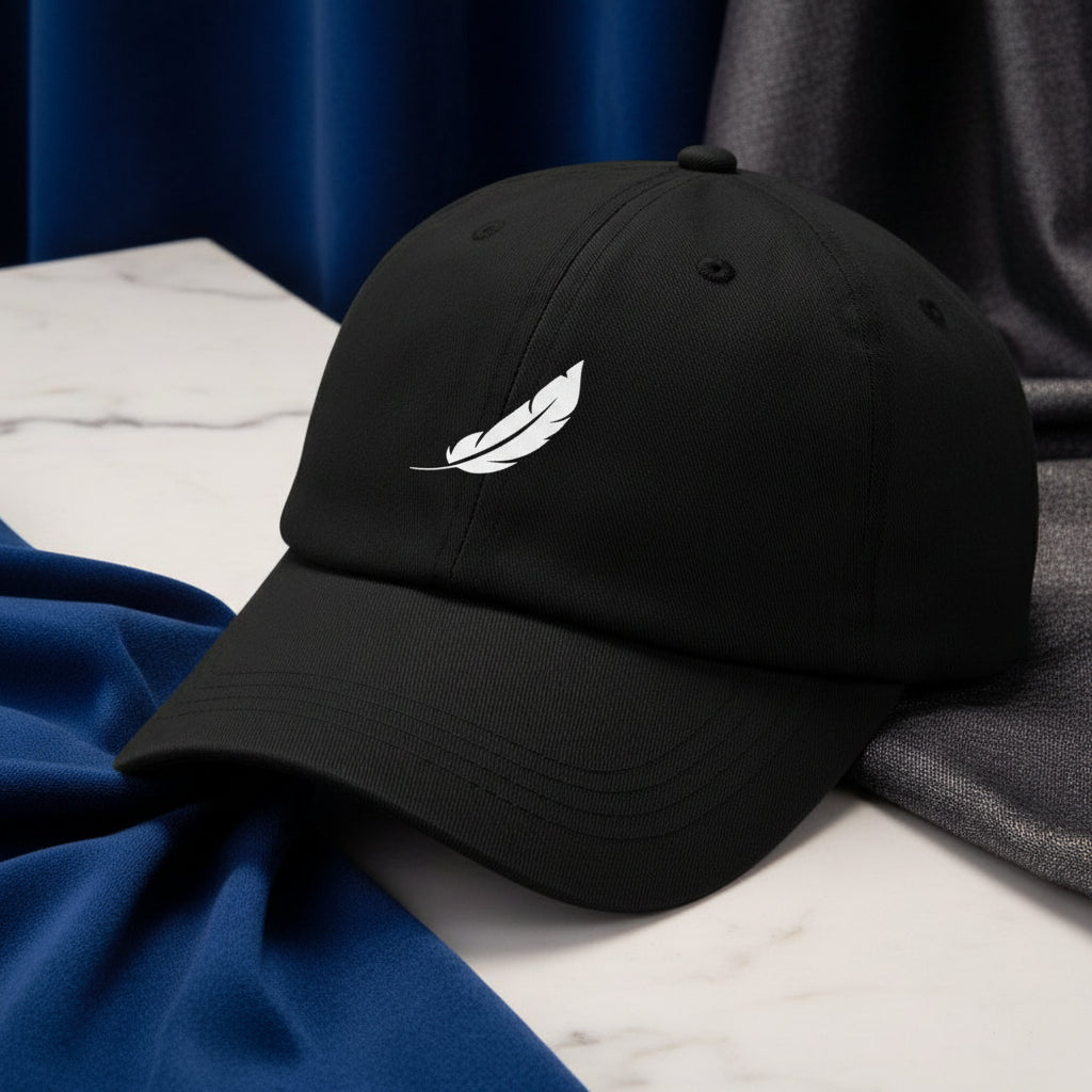 Black cap by flyliving with a white feather logo on the front, shown in a side view on marble.