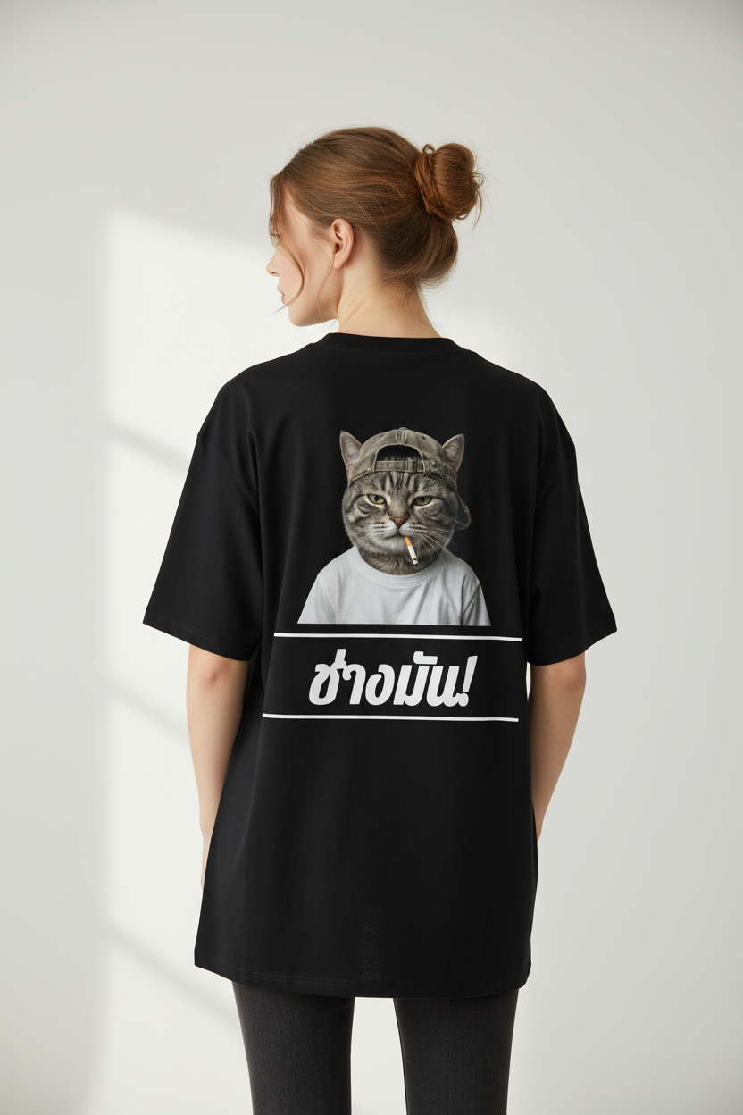 Black oversized unisex T-shirt by flyliving featuring a cat graphic and Thai text "ช่างมัน!" on the back.