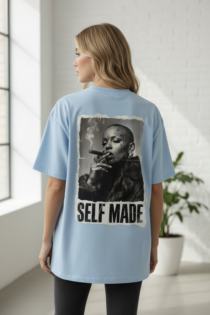 Light blue oversized T-shirt by flyliving, with a distressed 'self made' print on the back featuring a bald woman smoking a cigar.