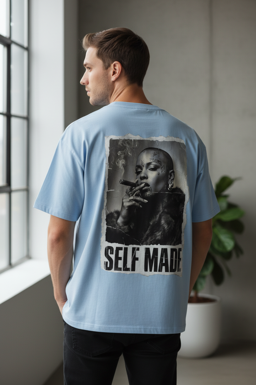 Light blue oversized T-shirt by flyliving, featuring a 'Boss Lady' print with 'SELF MADE' text on the back, worn by a man in black jeans.
