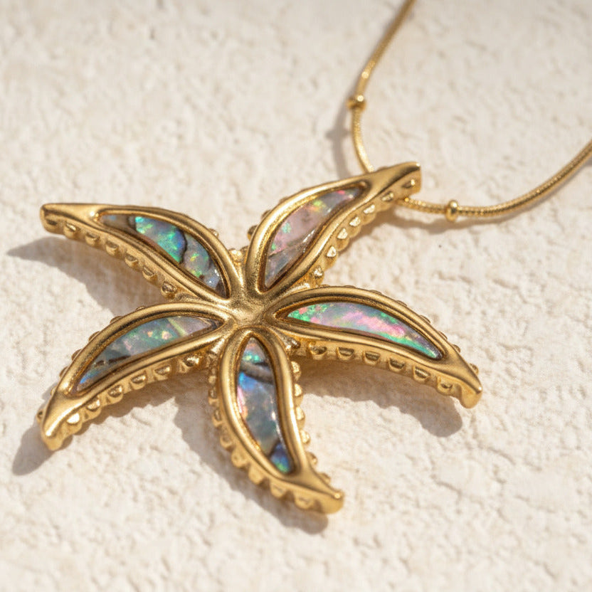 Gold-toned starfish necklace by flyliving, with iridescent mother-of-pearl inlay and textured beaded edges.