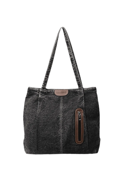 Die mittelgroße Handtasche „Blue Jeans“ von flyliving für Frauen besteht aus dunkelgrauem Denim, hat zwei Tragegriffe, eine braune Reißverschlusstasche aus Leder auf der Vorderseite und ein kleines braunes Etikett – perfekt für legere Ausflüge.