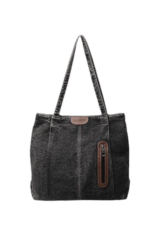 Die mittelgroße Handtasche „Blue Jeans“ von flyliving für Frauen besteht aus dunkelgrauem Denim, hat zwei Tragegriffe, eine braune Reißverschlusstasche aus Leder auf der Vorderseite und ein kleines braunes Etikett – perfekt für legere Ausflüge.